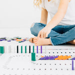 Child toppling wooden dominoes on a domino map