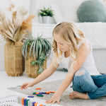 Little girl using wooden dominoes for open ended play. 